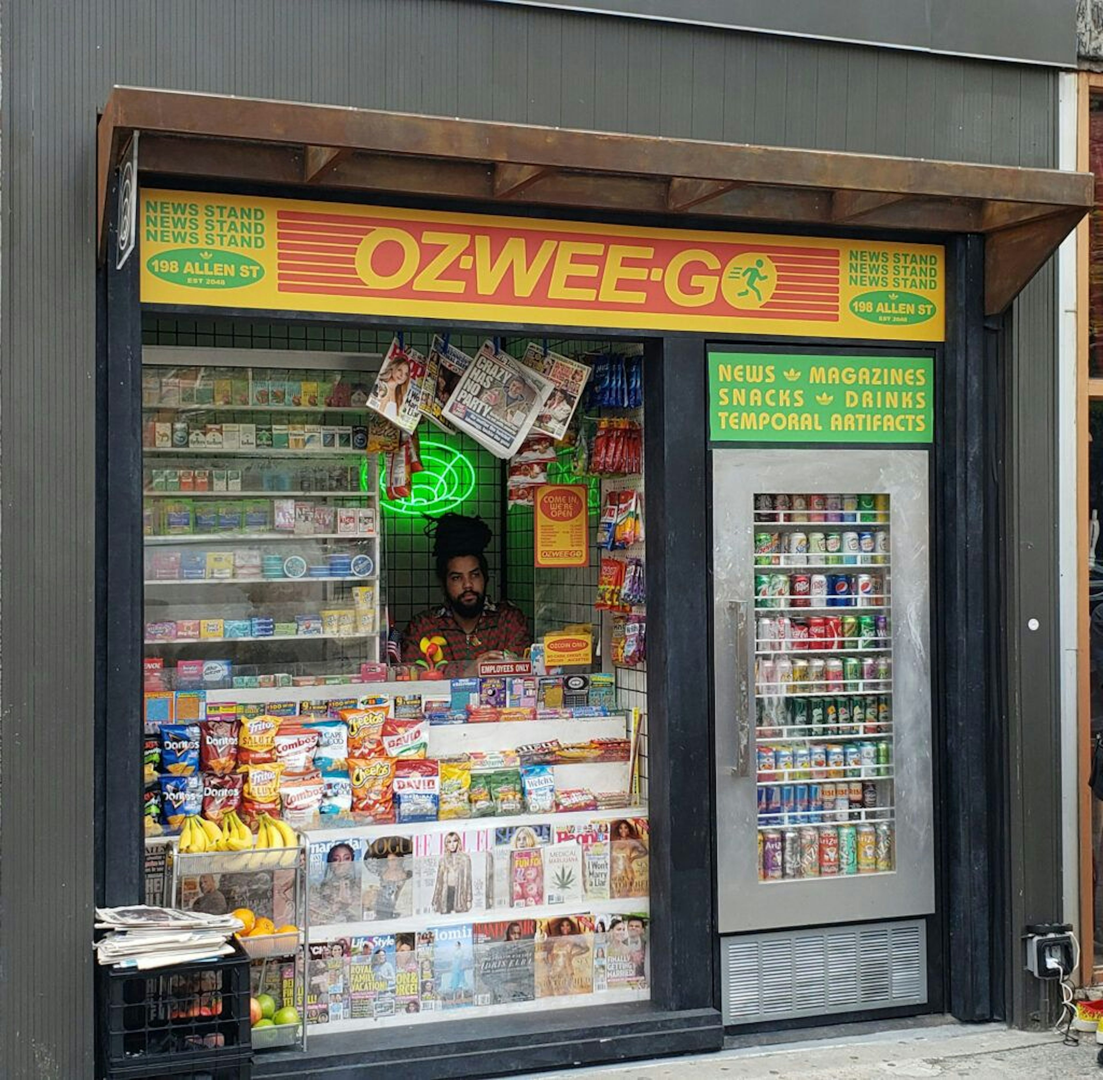 A cashier sits at the street-level Oz-wee-go bodega.